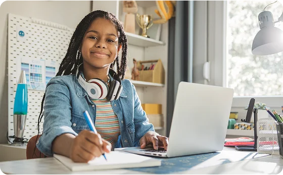 Student taking notes at home with her laptop