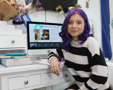 Student attending to an online class wearing a stripped sweater