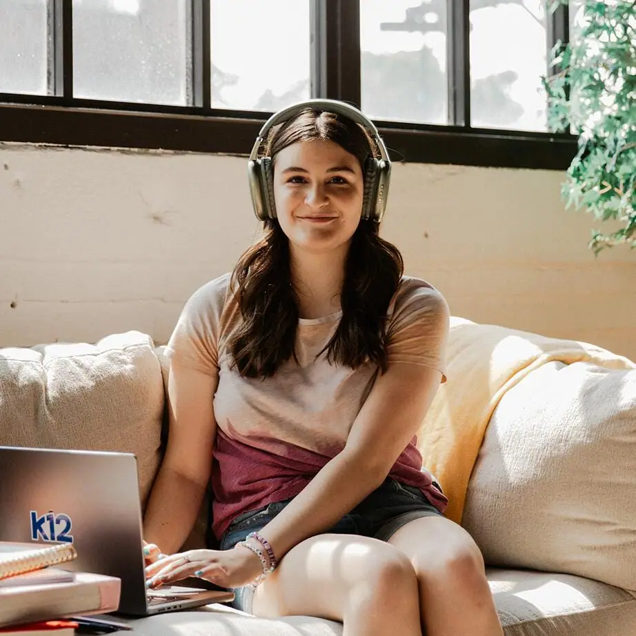 Student wearing a pair of headphones while is using her laptop
