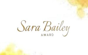 Sara Bailey Award text in gold cursive and bold caps on a white background with yellow accents.